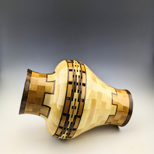 Segmented Vase with open segments and a hidden box. Made of maple, cherry and walnut. Designed and crafted in Canada by Simon Roy