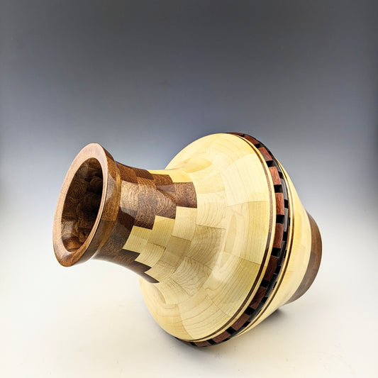 Segmented vase with open segments. Made of maple, sapele, bloodwood and wenge. Designed and crafted in Canada by Simon Roy