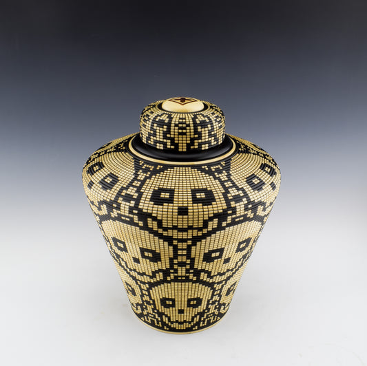 Basket illusion vase with a threaded lid by Simon Roy. Features stacked skulls. made of Maple and india ink. Handmade in Canada.